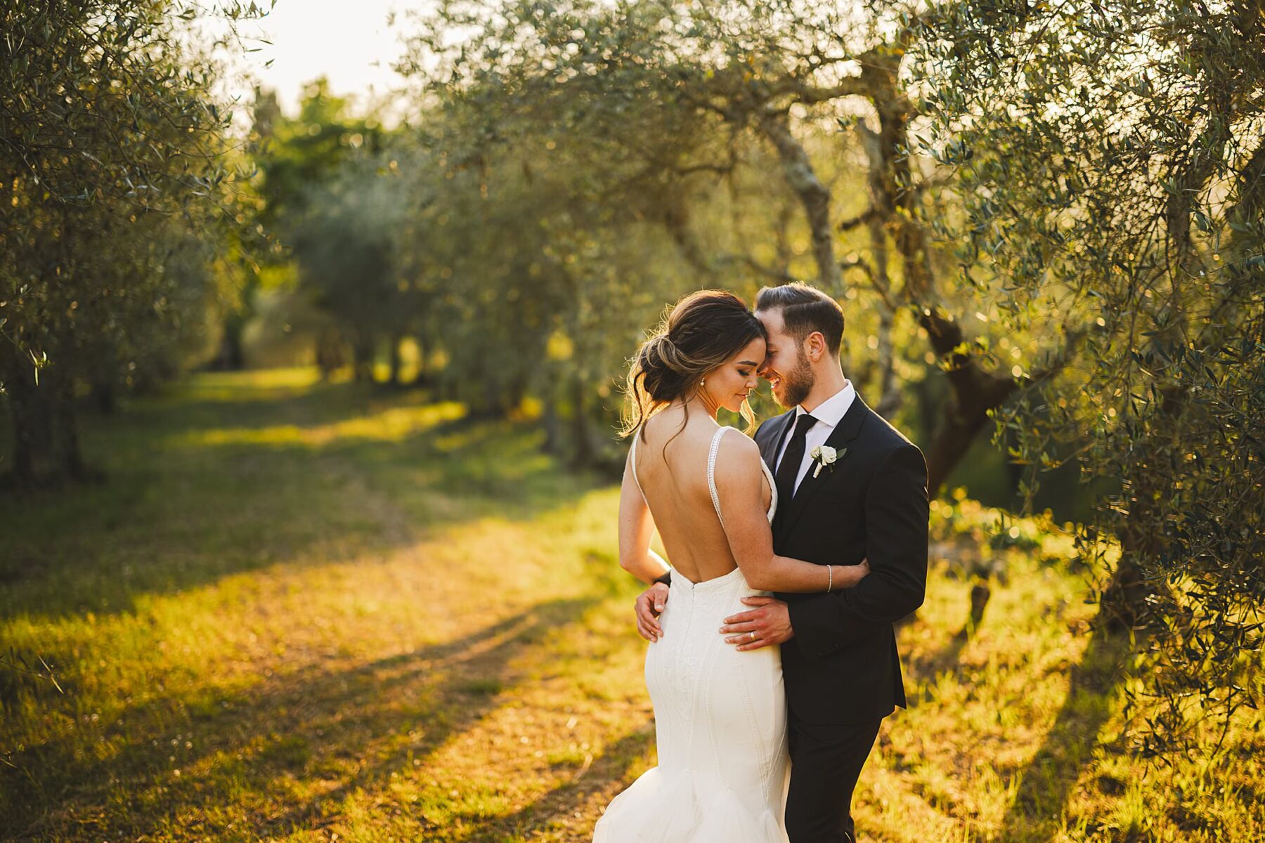 Dreaming intimate bride and groom wedding portrait in the evocative olive groves of Borgo Stomennano during golden hour