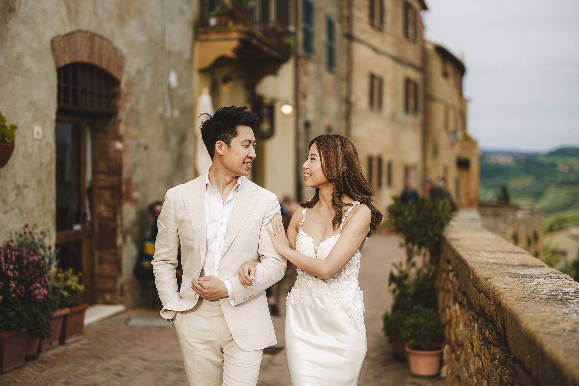 Lovely couple walk in Pienza streets during a pre-wedding photo session