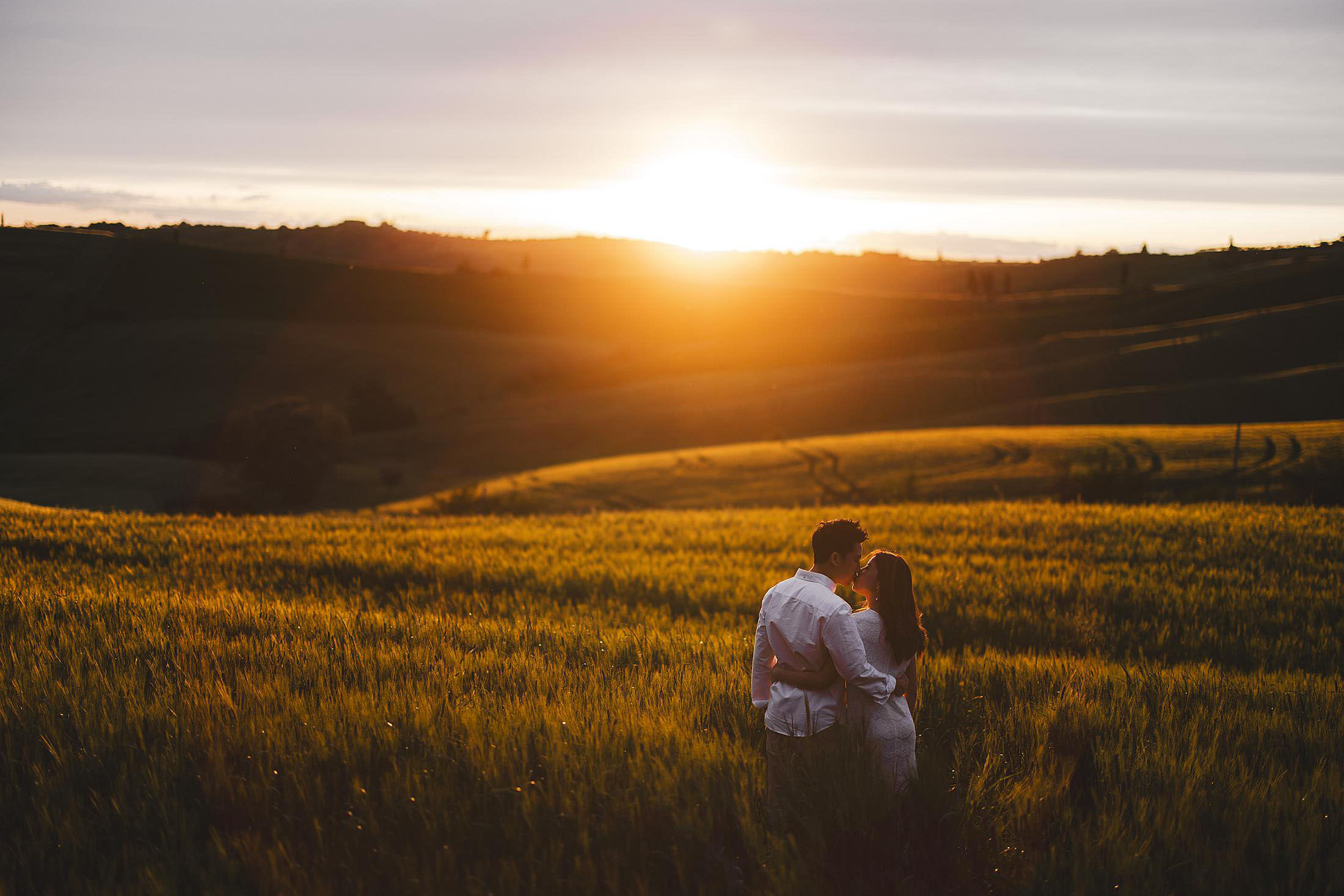 Romantic and unforgettable couple pre-wedding sunset photo in a dreaming countryside rolling hills of Val d’Orcia near Pienza