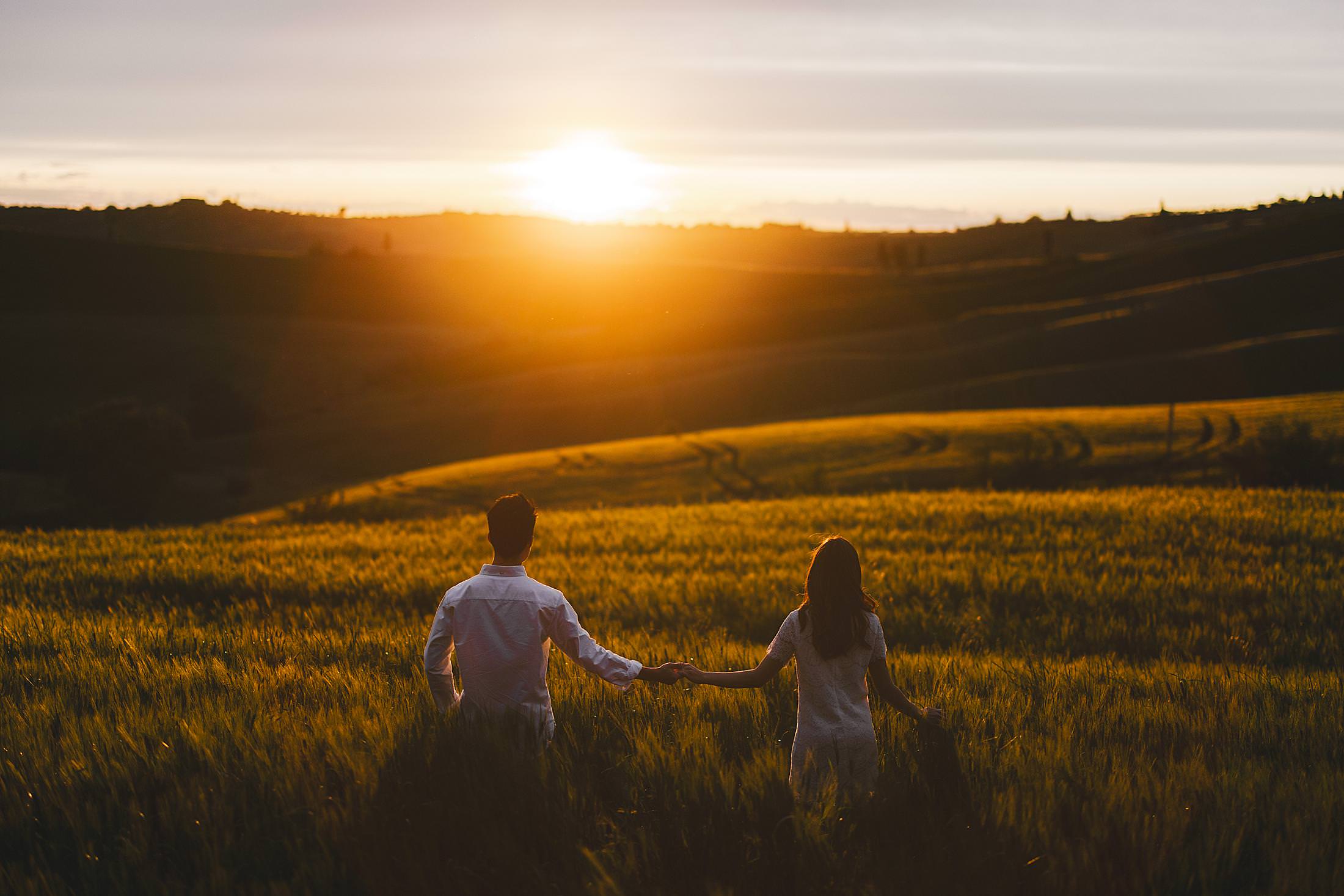 Pienza countryside couple engagement photo session at sunset with gorgeous rolling hills at golden hour