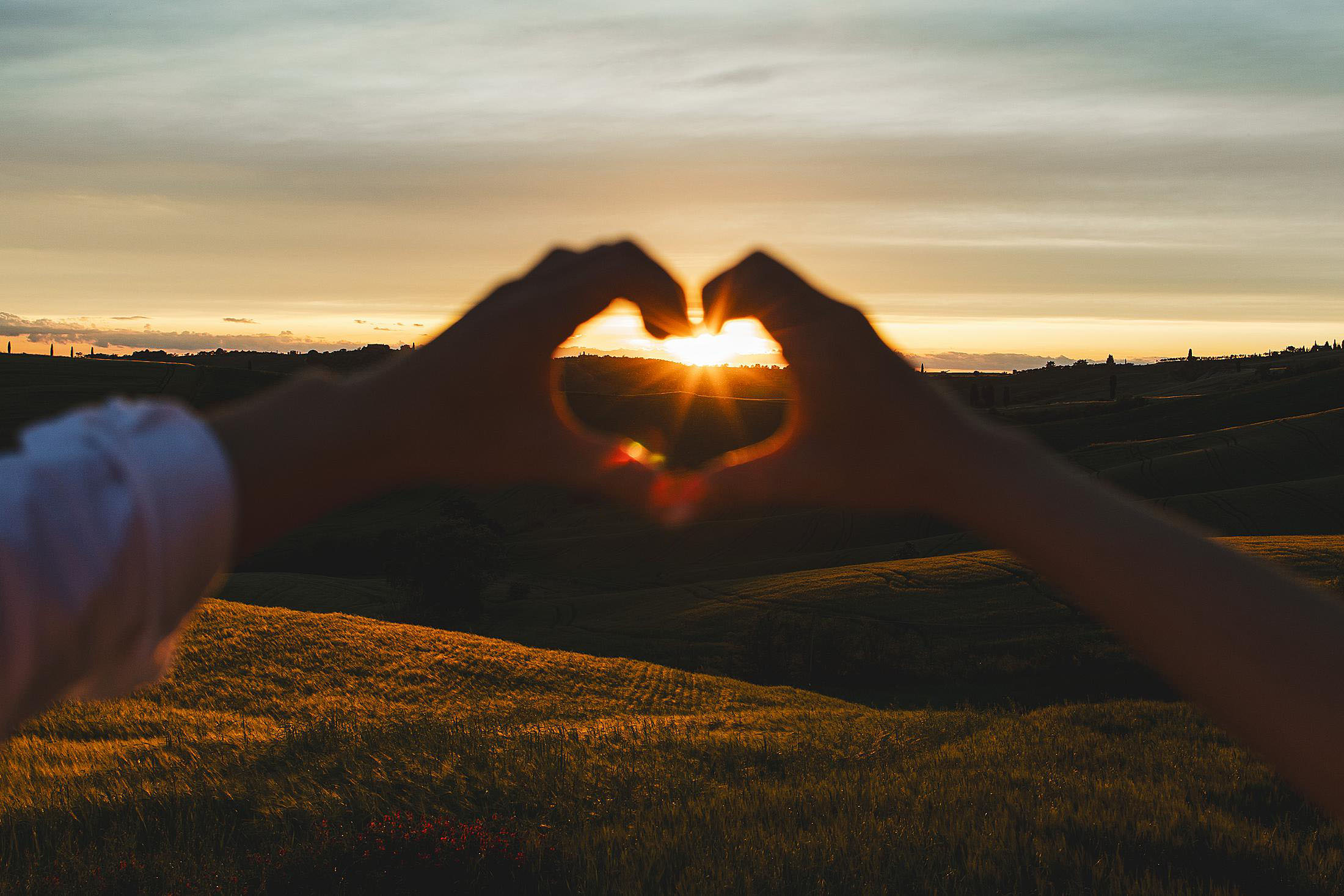 Pienza countryside couple engagement photo session at sunset with gorgeous rolling hills at golden hour